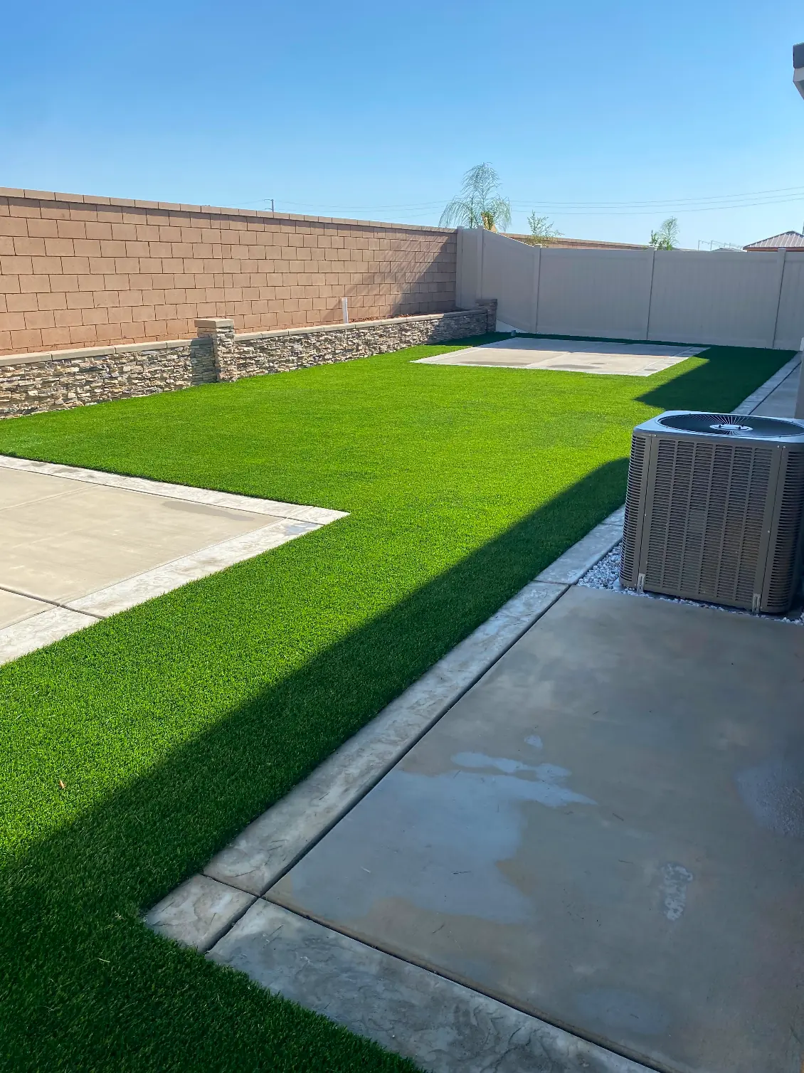Yard bounded by block wall and vinyl fence in Perris, CA