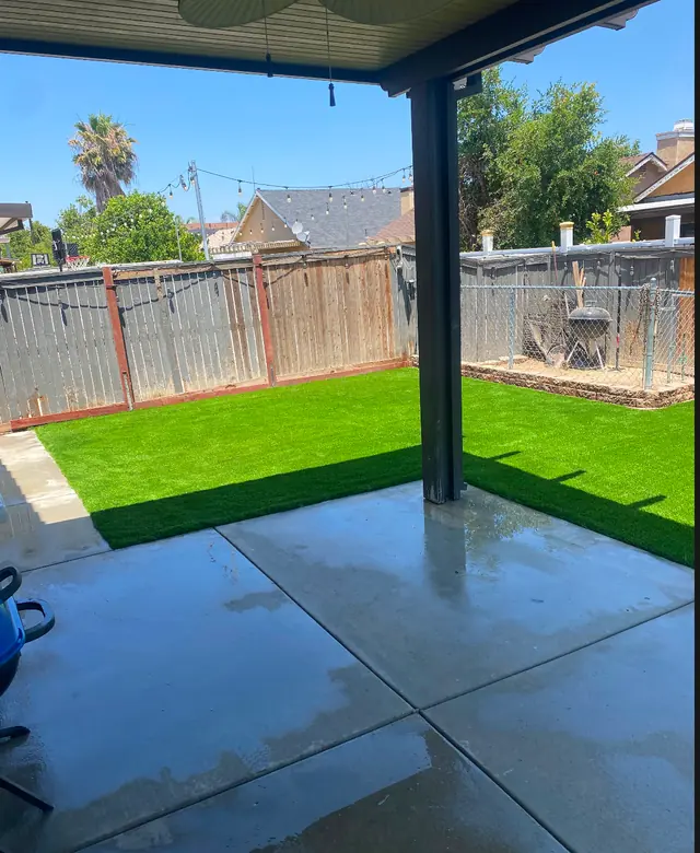 Back yard with turf under a patio cover in Perris, CA