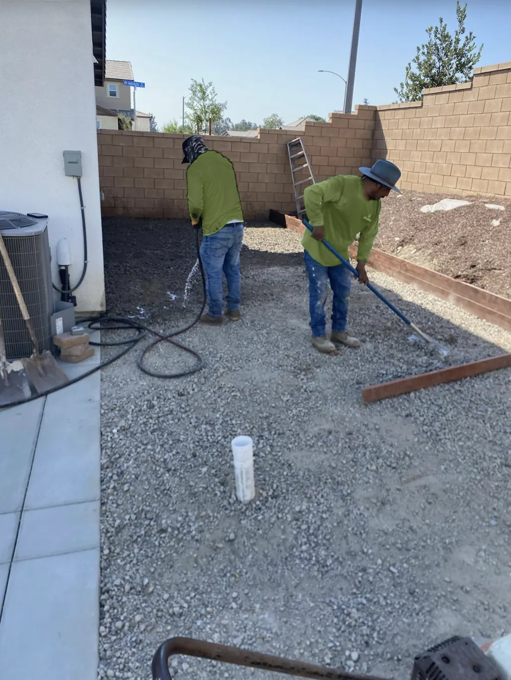 Crew spreading and compacting a gravel base for artificial grass
