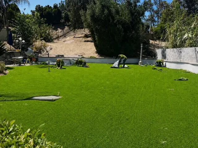 Crew installing artificial turf on a large yard in Perris, CA