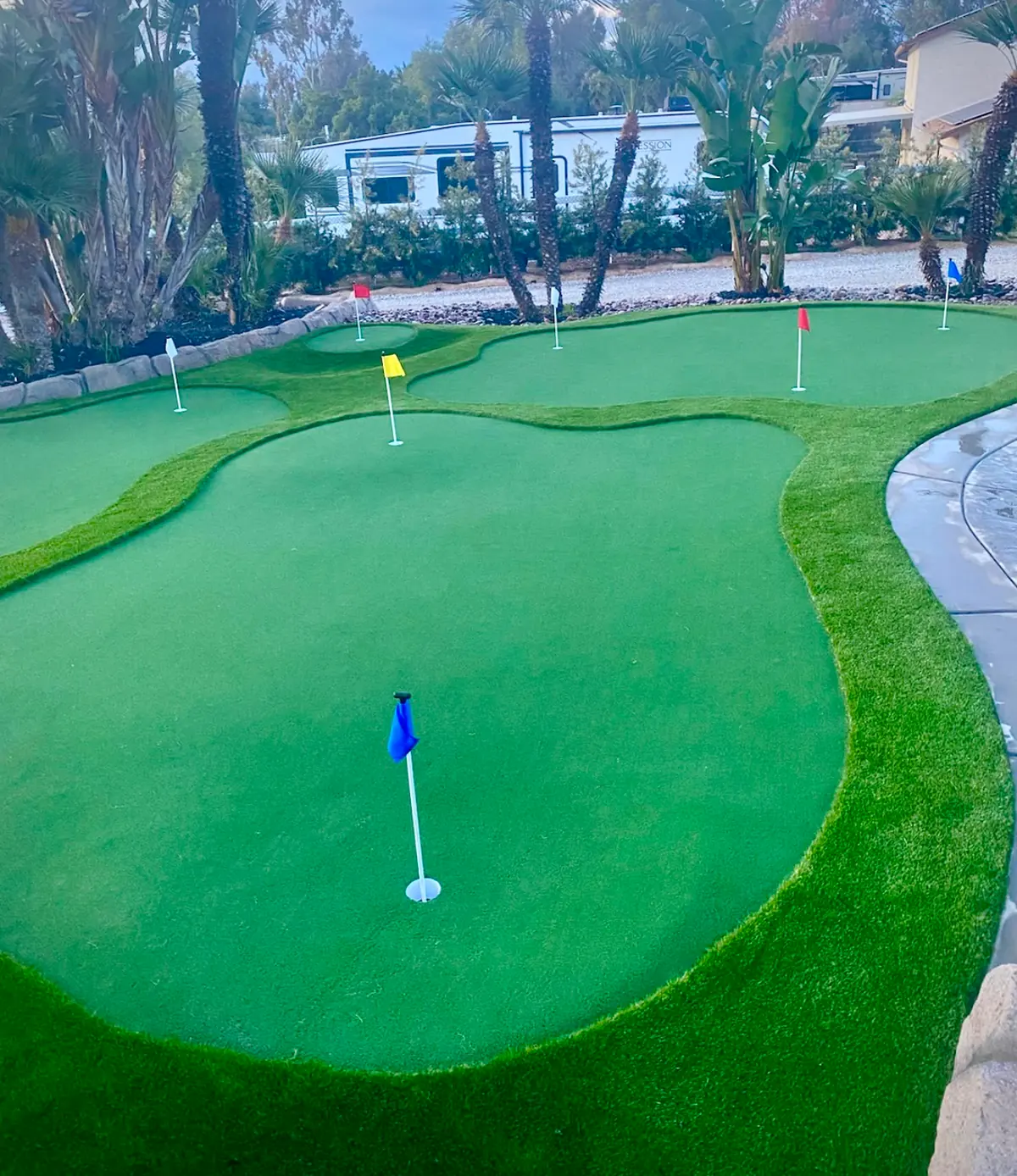 Backyard putting green with several flags in Perris, CA